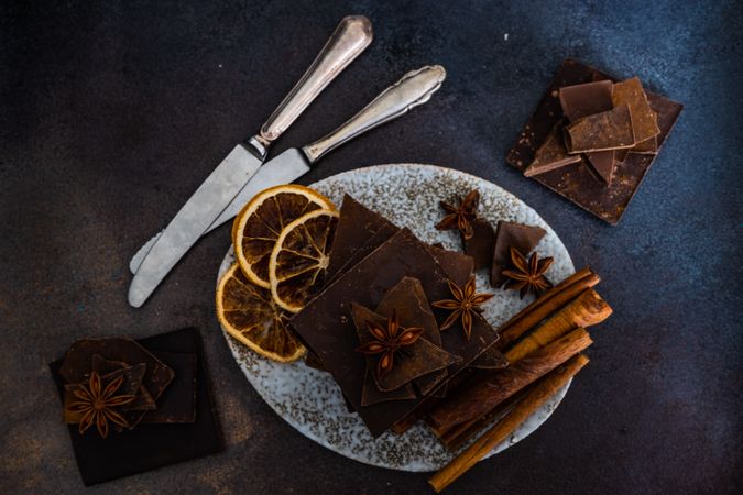 Chocolate bars, cinnamon and anise star spices on plate