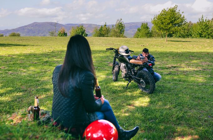 Couple resting from a motorcycle trip taking picture