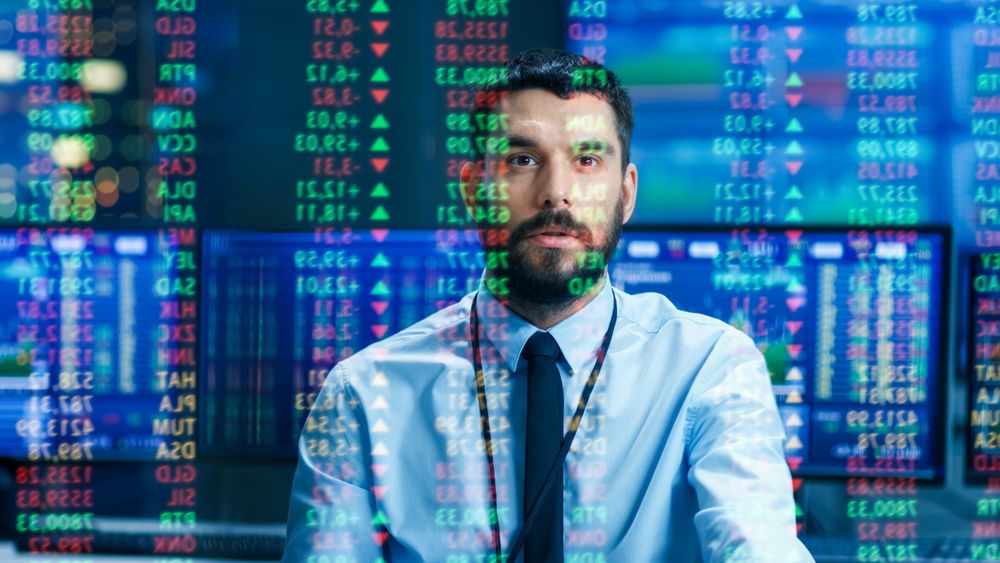 Stock Market Top Trader Looks at Projected Ticker Numbers and Graphs Running, Analysing Data to Make Best Sell.