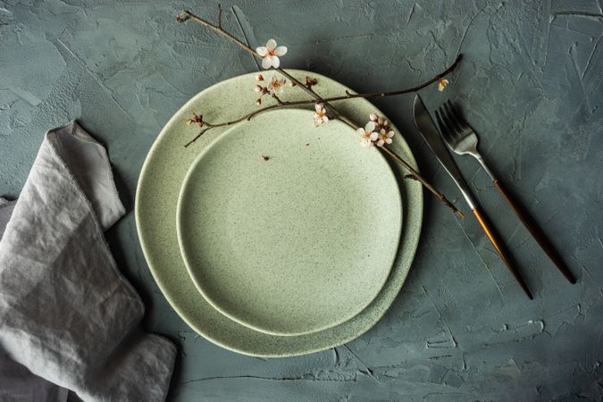 Top view of elegant spring table setting with delicate cherry blossom tree branch