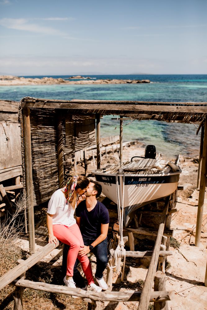 Loving couple hugging near boat dragged ashore