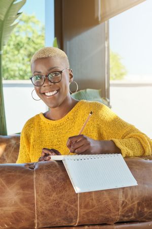 Smiling Black woman writing in planner at home