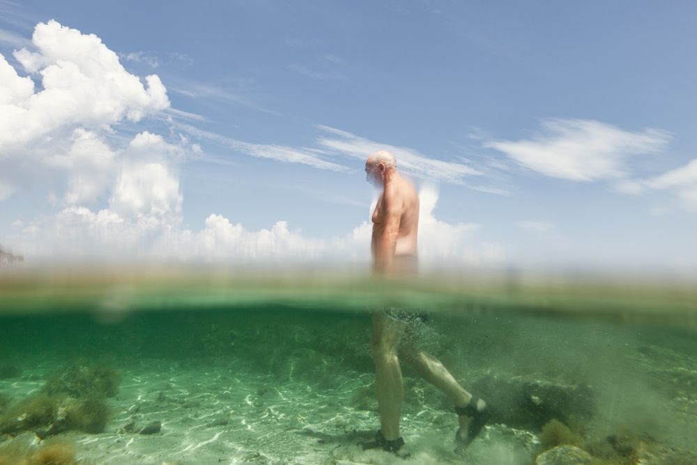 Cheerful man swimming in sea water