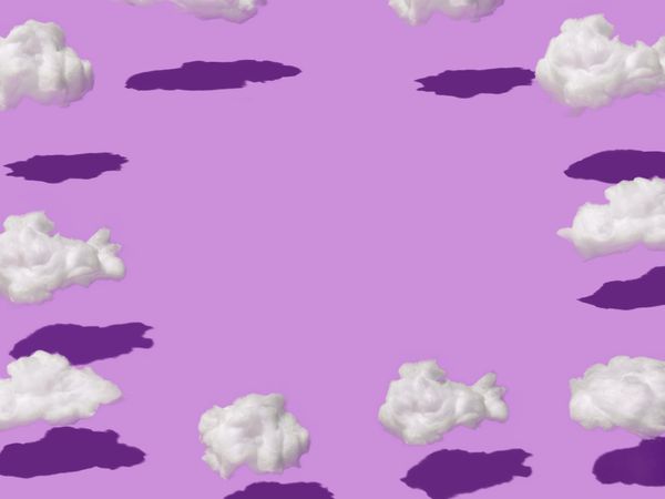 Purple background with fluffy clouds and copy space