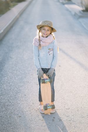 Stylish girl with skateboard on street
