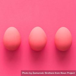 Row of three pink Easter eggs on pink background 4OW8j4