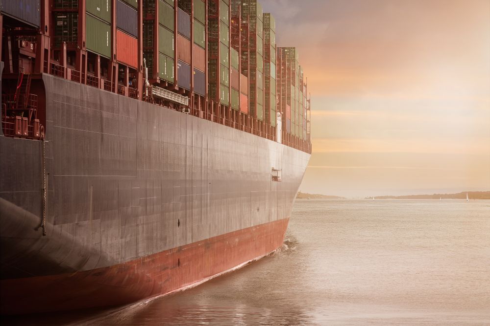 Cargo ship on sea during sunset