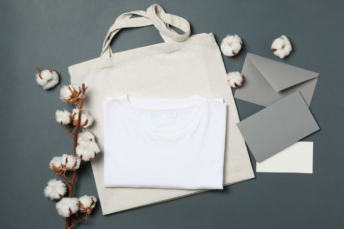 Cotton, bag, t-shirt and envelope on light dark background, space for text