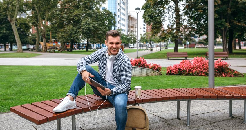 Young white man with tablet outdoors
