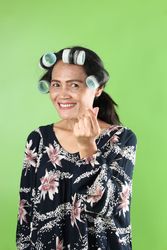 Asian Woman In Hair Rolls Wearing Making Heart Sign
