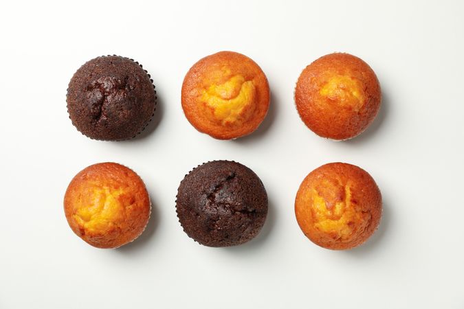Flat lay with tasty muffins on light background, top view
