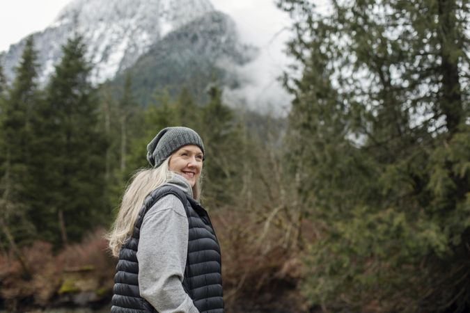 Happy woman in the woods looking at the scenery