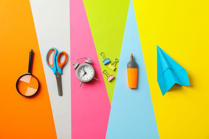 Flat lay composition with school supplies on multicolor background, space for text