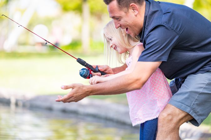 Young Father and Daughter Having Fun Fishing At The Lake