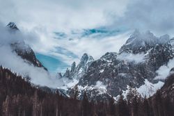Snow covered mountain under cloudy sky