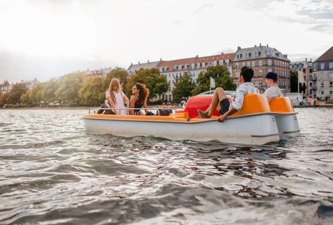 Group of people enjoying boating on city river