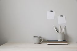 Empty desk with office supplies and beige wall copy space