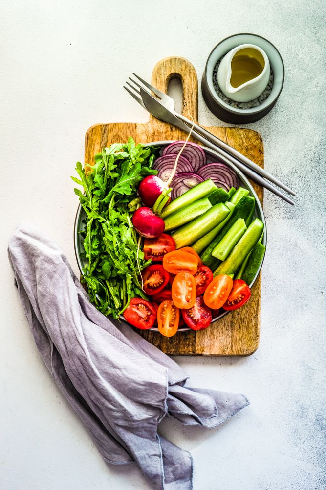 Top view of healthy chopped vegetables on bread board