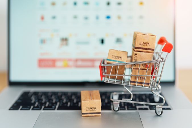 Online Shopping Concept with Cart and Parcels on Laptop Keyboard