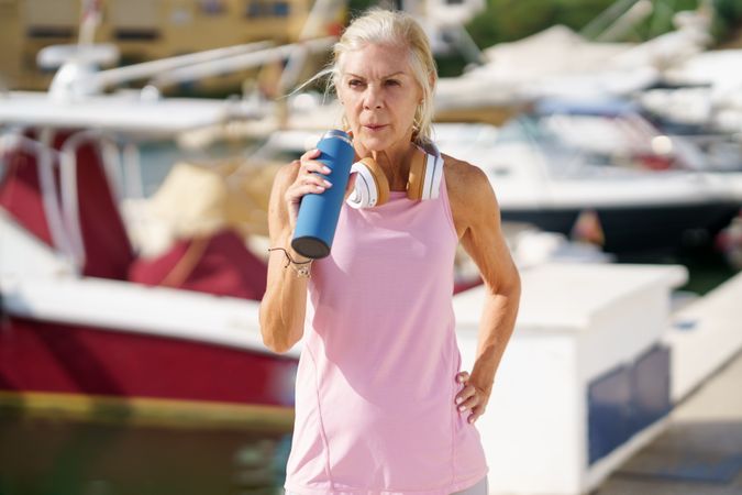 Mature sportswoman drinking between exercise
