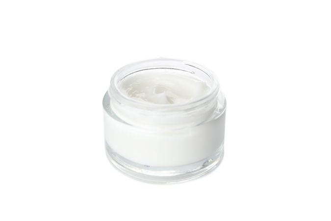 Cosmetic cream in glass jar isolated on blank background