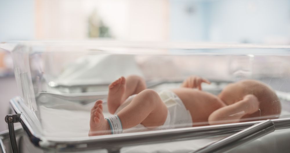 Cute Little Newborn Baby Lying in Bassinet in a Maternity Hospital.