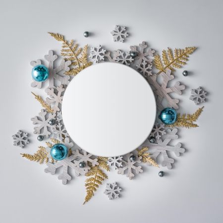 Festive winter decoration and snowflakes behind circle paper card