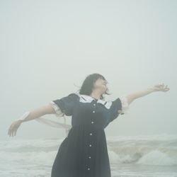 Woman in dark dress dancing on beach