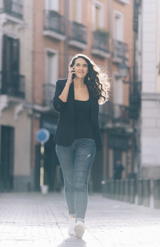 Young female walking with smartphone