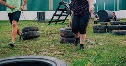 Participants in an obstacle course dragging wheels