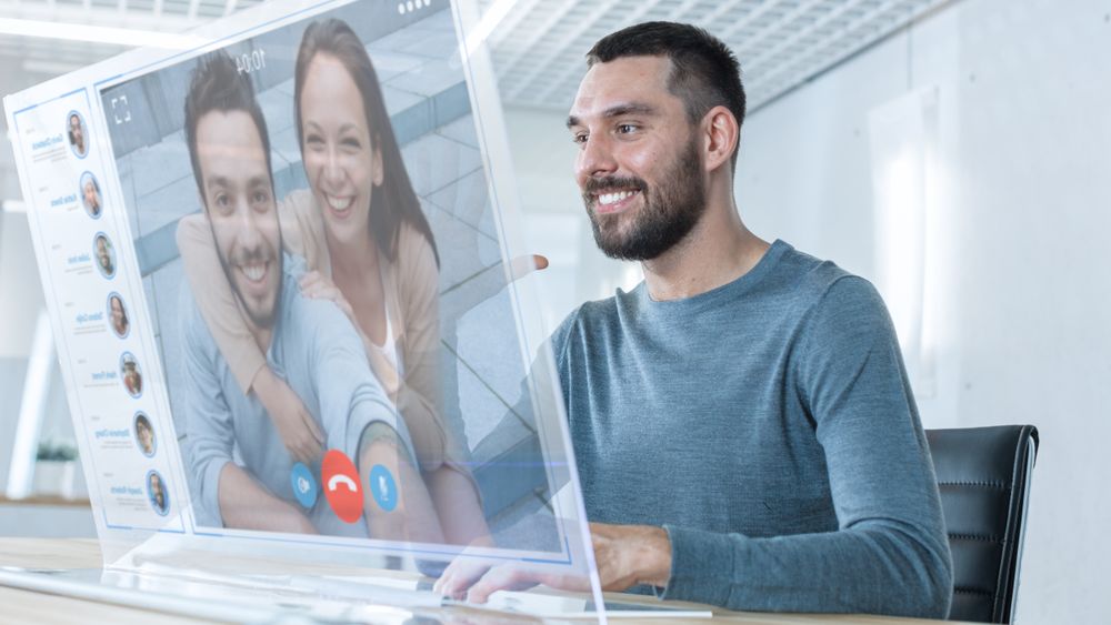 In the Near Future Man Makes Video Call from Computer with Transparent Display to His Friends.