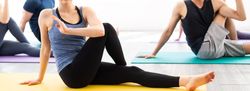 Woman twisting and stretching her body on a yoga mat