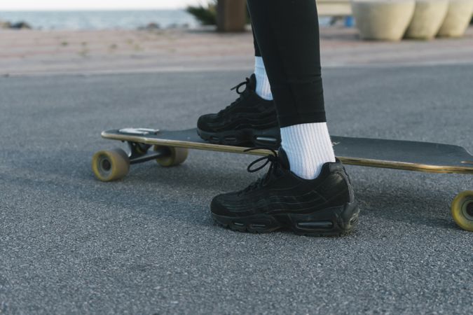 Feet of woman riding on skateboard on the street