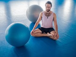 Male meditating in spacious room