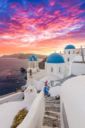 Colorful clouds over the iconic blue domes of Santorini