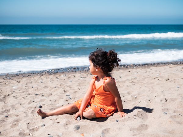 Little girl sitting on beach