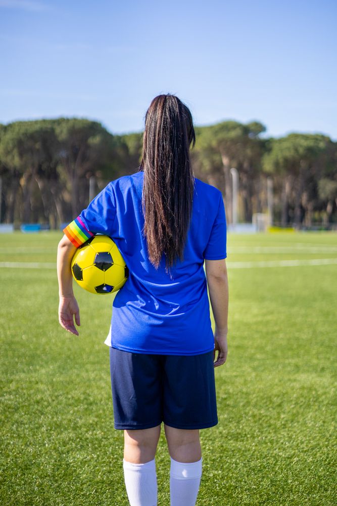 Back of female soccer player with rainbow armband