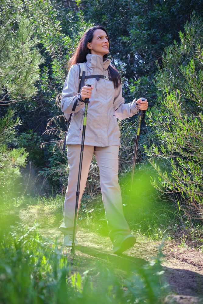 Hispanic woman hiking on path in forest