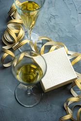 Gift box concept with gold bow and champagne