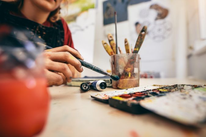Women's hand with brush painting in studio