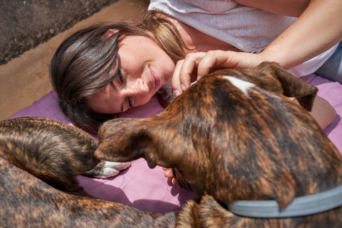 Loving young female petting dog outside