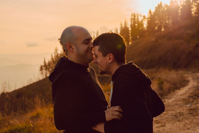Men hugging and kissing in forest