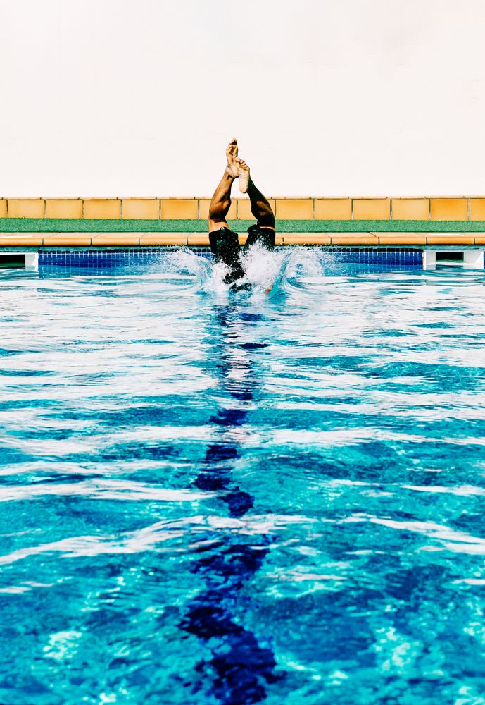 a man enters the pool in a sunny day