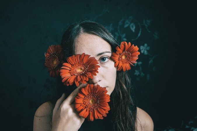 Portrait of woman with blue eyes holding gerbera flower