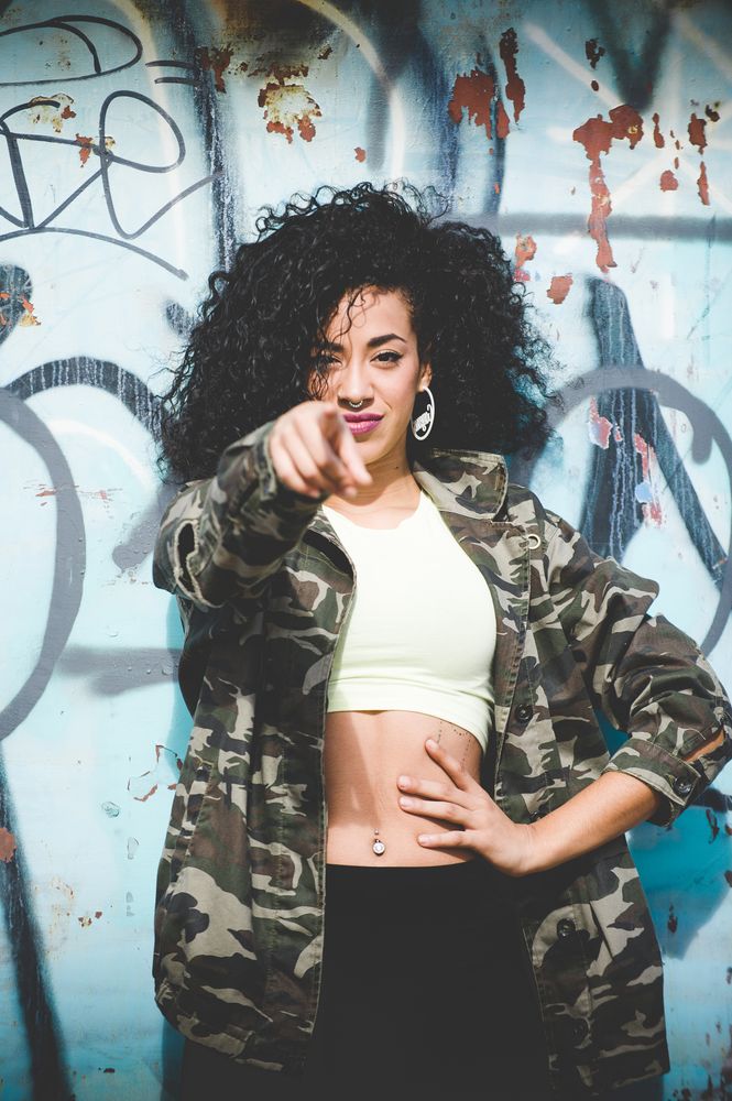 Trendy sportive woman pointing at camera confidently