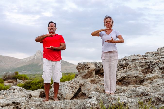 Couple meditating on rock