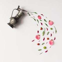 Tea pot pouring various natural herbs