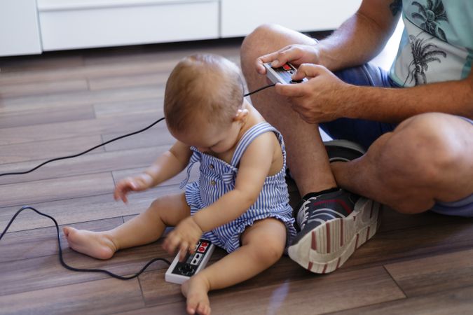 Anonymous father and baby playing video games