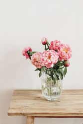 Elegant vase of pink flowers on wooden table