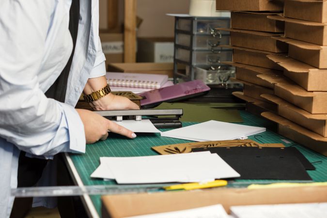 Female hands use hole punch to create perforations in removable paper blocks